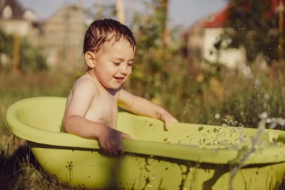 Criança brincando na banheira durante um banho morno